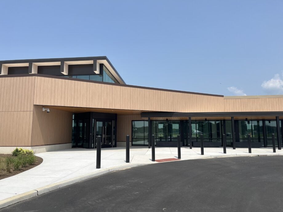 A view of the entrance of Cape May Airport featuring Enigma Oak Max Compact Exterior phenolic panels, installed seamlessly above the glass windows on the entrance