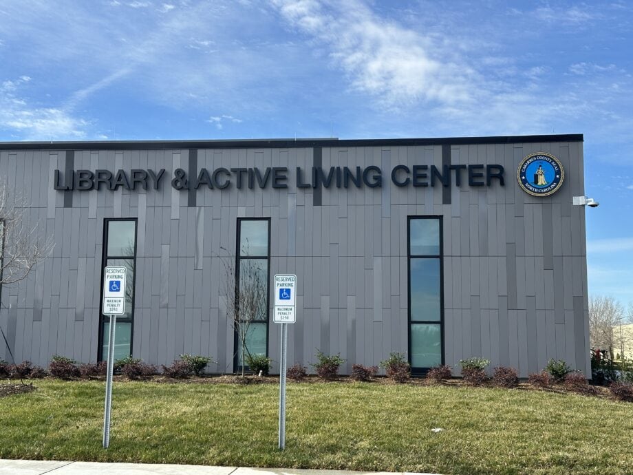 A close image of signage featuring "Library & Active Living Center" in black letters and Dark Grey phenolic panels behind it